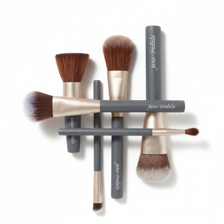 Set of Jane Iredale makeup brushes with advanced fiber technology on a white background