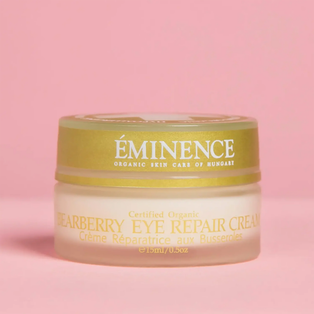 Jar of Eminence Bearberry Eye Repair Cream on a pink background