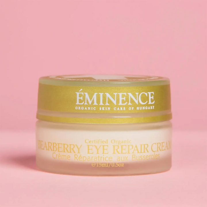 Jar of Eminence Bearberry Eye Repair Cream on a pink background