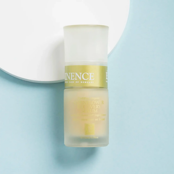 Skincare bottle with a gold label on a light blue background