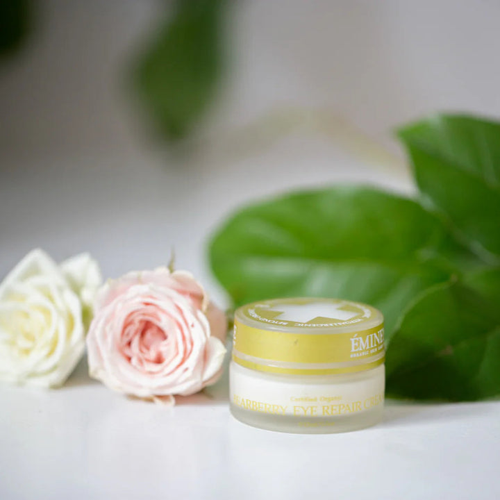 Cosmetic jar with flowers and leaves on a light background