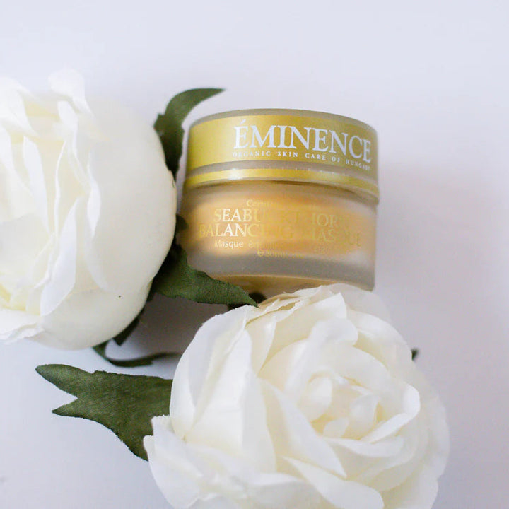 Eminence skincare product with white roses on a light background